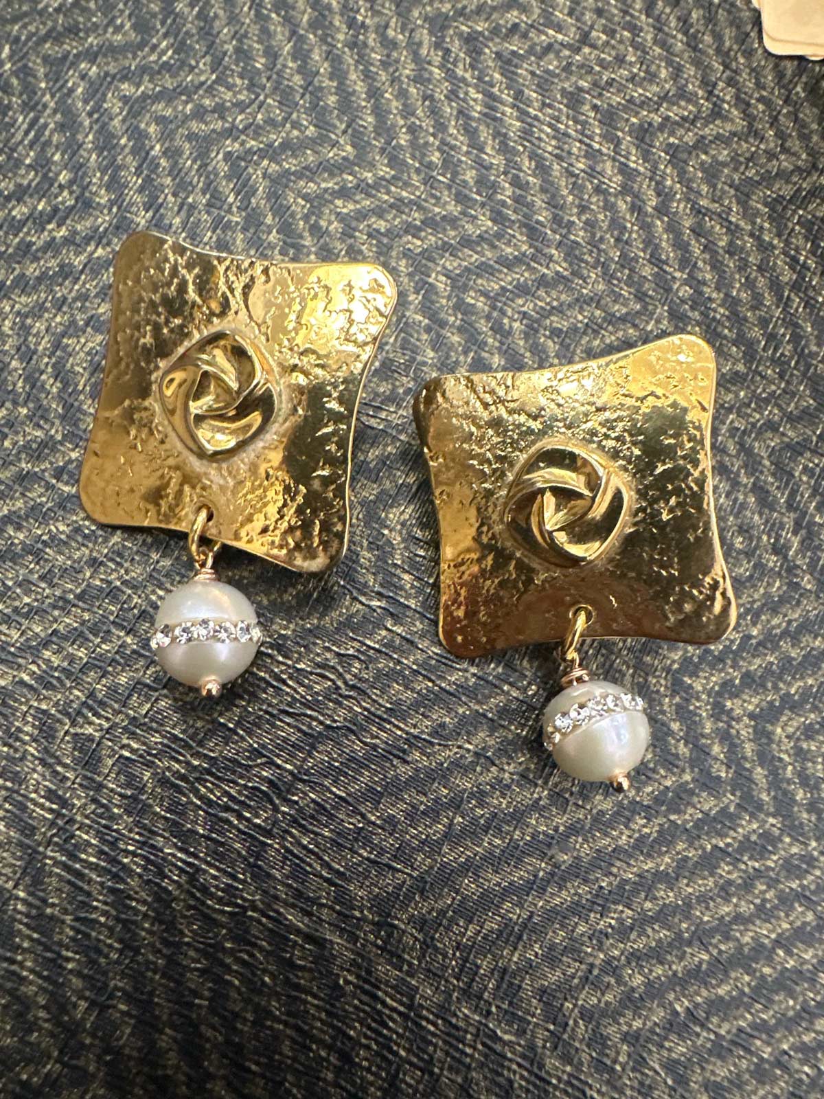 a pair of gold earrings with pearls