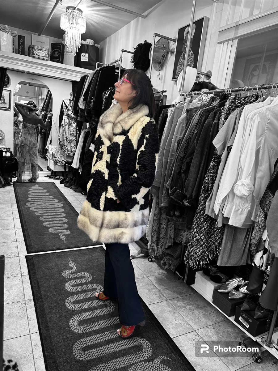 a woman in sainted goods store wearing a black and white fur trimmed coat